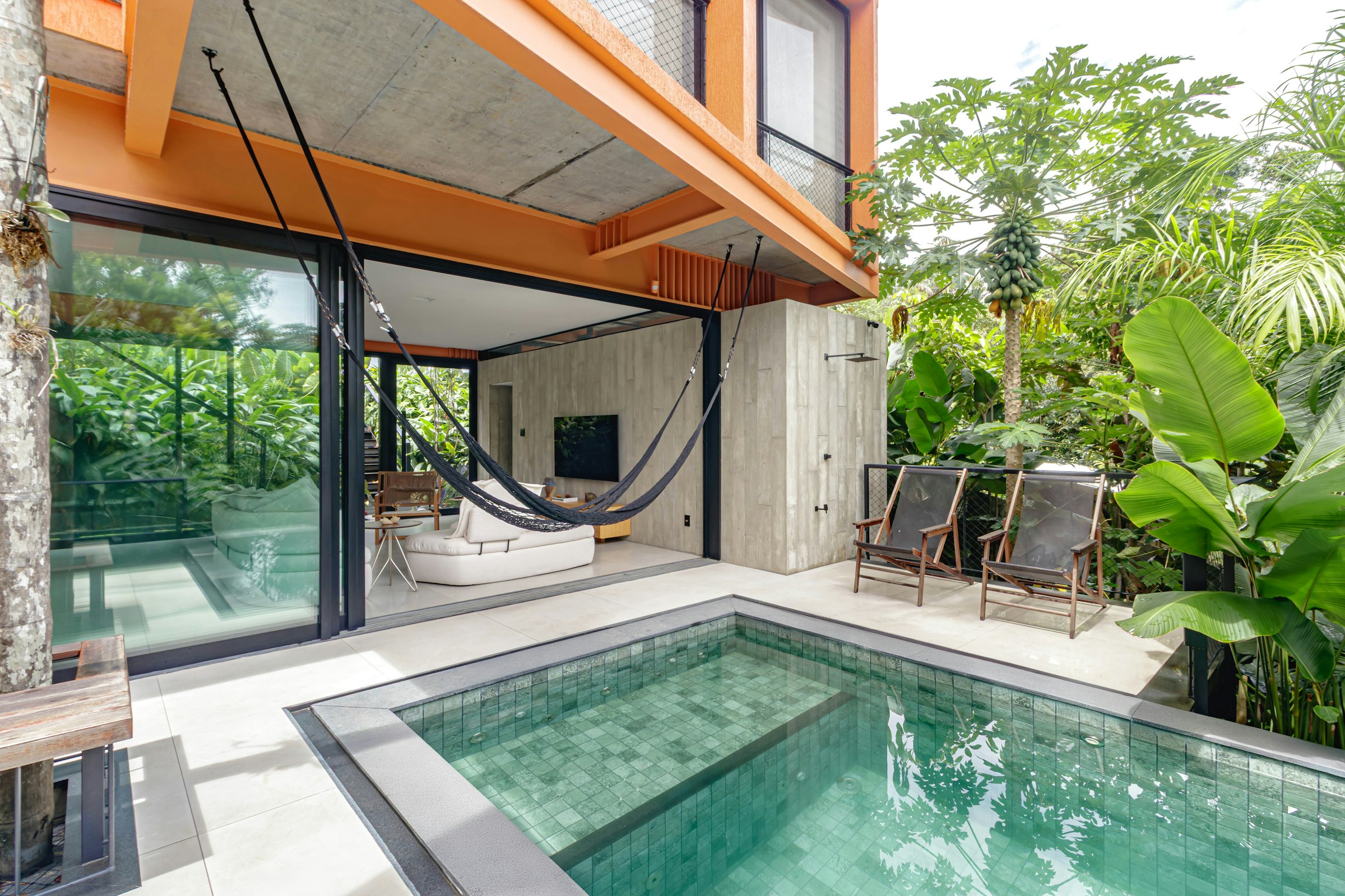 Vivienda contemporánea integrada en un jardín residencial con piscina; imagen ilustrativa, no corresponde a un modelo analizado